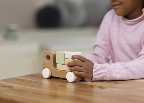 niña-jugando-con-coche-de-madera