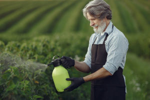 agricultor-fumigando-plantas-cabecera